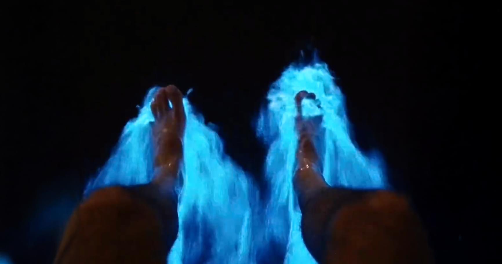 Guest's feet create bioluminescence in the Cayman Islands water at night.