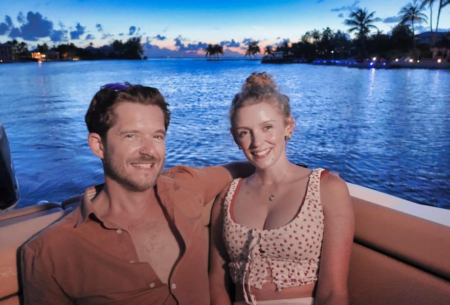 Couple enjoying a peaceful boat ride at sunset in Grand Cayman Bioluminescent Bay.