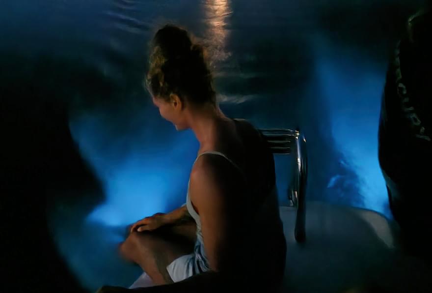 Woman sitting on a boat with glow in the water.