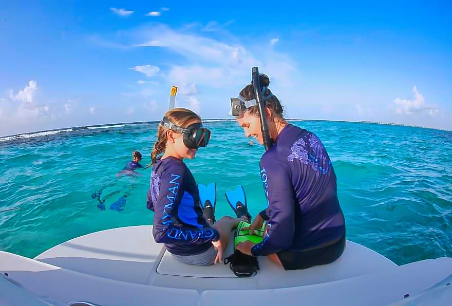Mother and daughter preparing for a snorkeling tour in the Cayman Islands
