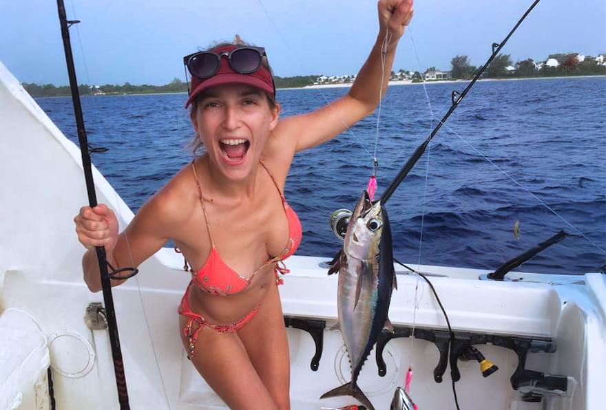 Angler holding a tuna after a successful trip with deep sea fishing in Grand Cayman