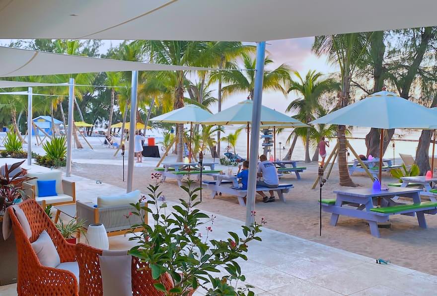 Relaxed beachside seating at Rum Point with palm trees and ocean views
