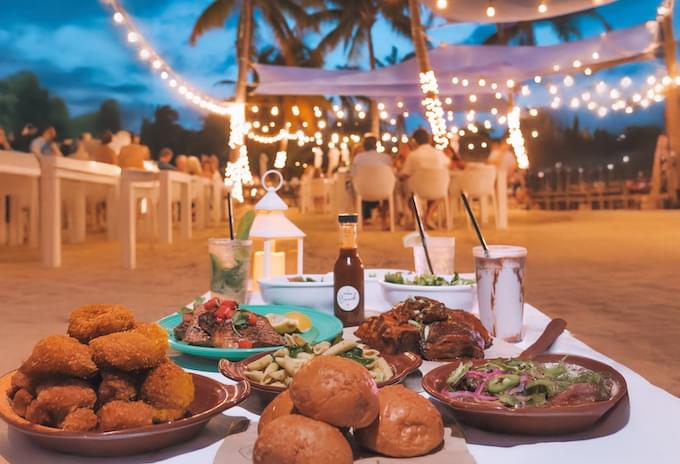 Evening dining setup at Kaibo Beach BBQ with string lights and beachfront views in Grand Cayman