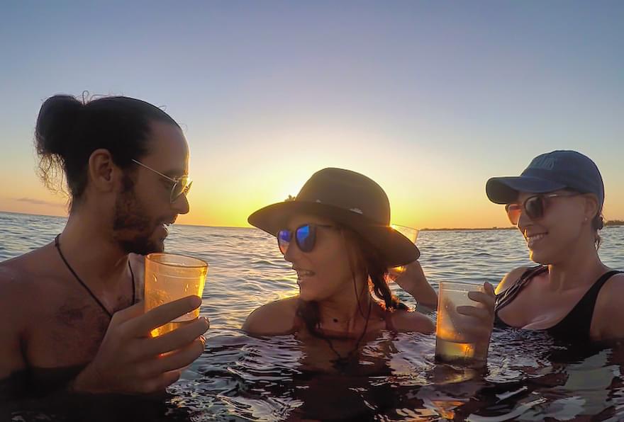 Friends celebrating with drinks during a sunset cruise.