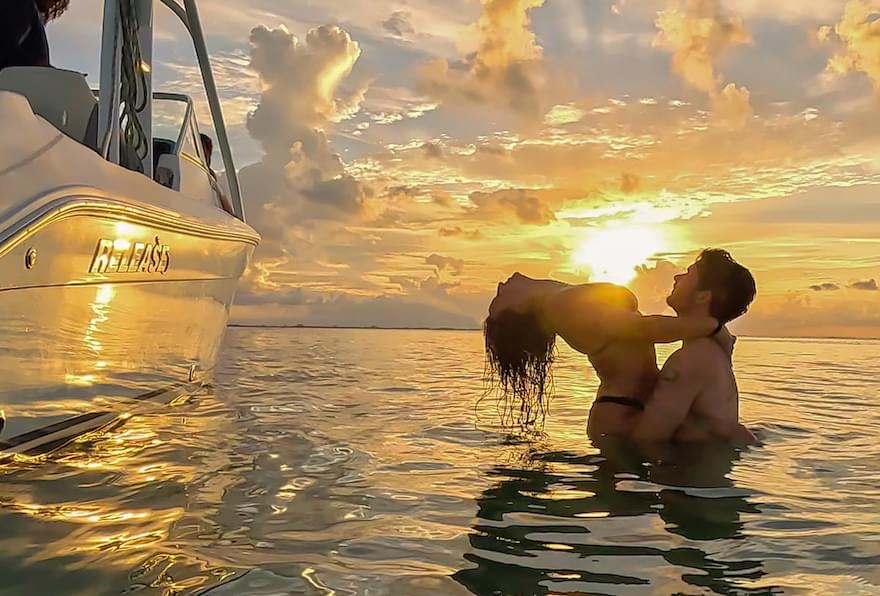 Couple enjoying a romantic moment during a sunset cruise in Grand Cayman.