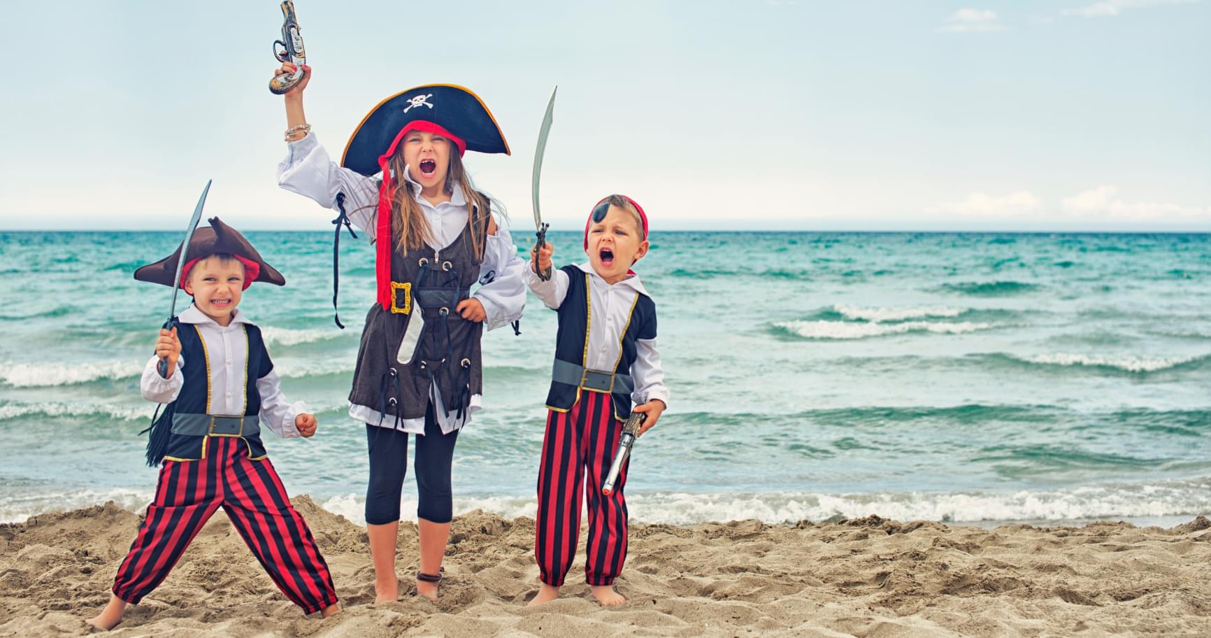 Children dressed as pirates on the beach, celebrating Pirates Week in the Cayman Islands