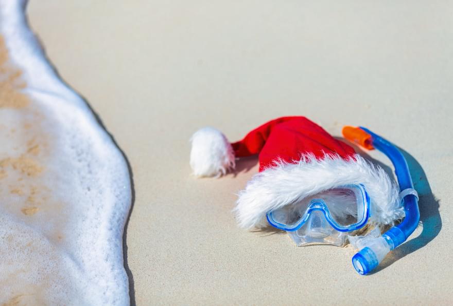 A Santa hat and snorkeling gear on the beach, celebrating the holiday season in Grand Cayman