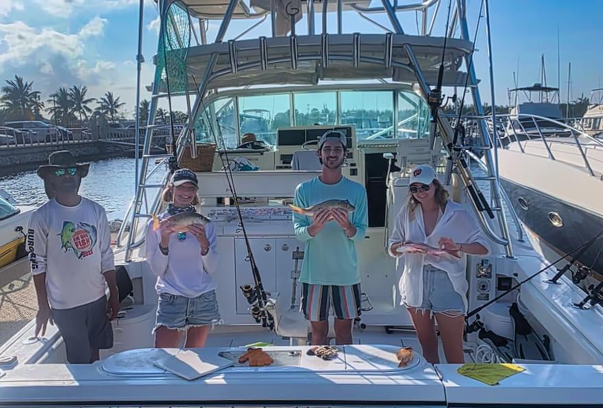 A group enjoying a fishing trip aboard a boat, showcasing Cayman Islands fishing seasons