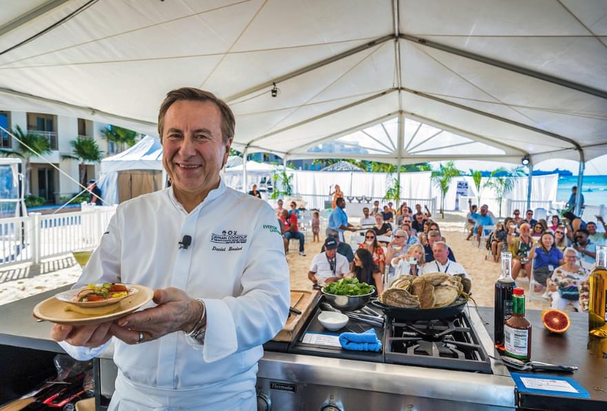 A chef serving fresh seafood at the Cayman Cookout, held during the best time to visit Grand Cayman Islands
