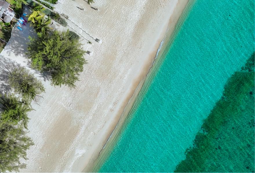 Aerial view of a tranquil beach on the East End, ideal during the Grand Cayman low season