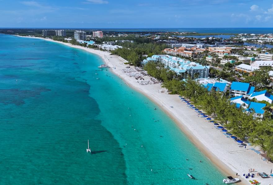 Aerial view of Seven Mile Beach with turquoise waters and pristine sand, found on a map of Grand Cayman