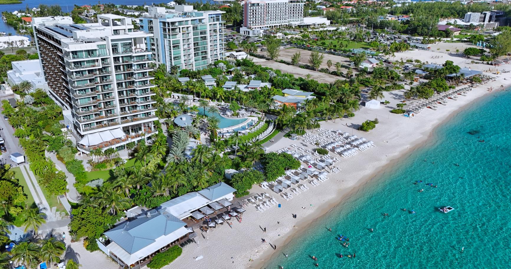 Aerial view of hotels and resorts along Seven Mile Beach, visible on the Cayman Islands map