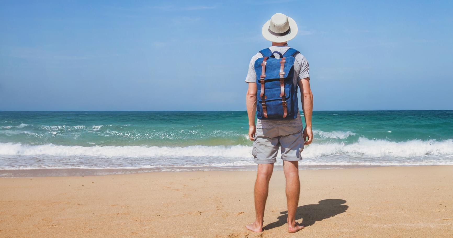 A solo traveler walking along a serene beach in Grand Cayman, enjoying the peaceful surroundings