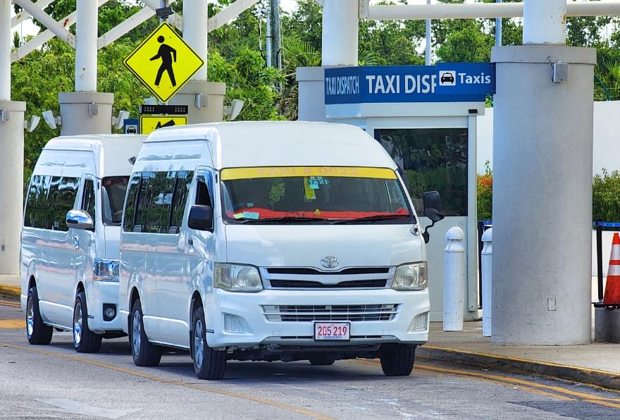 Shuttle vans lined up for a seamless Cayman Islands airport transfer from Owen Roberts International Airport