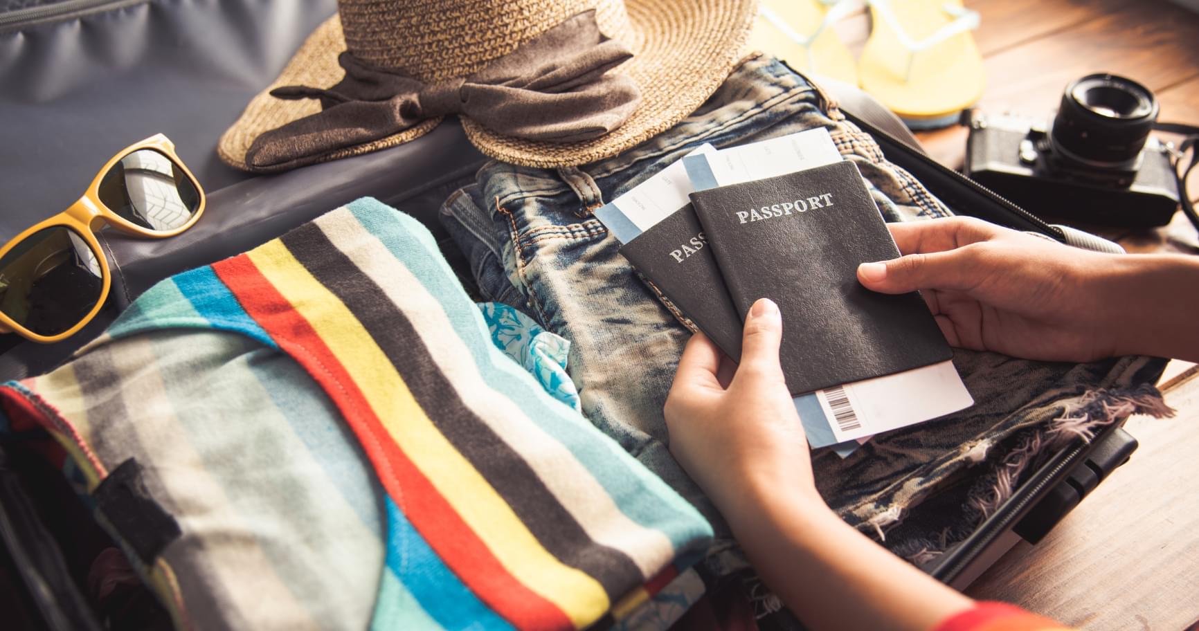 A traveler packing a suitcase with essentials for a tropical getaway after reviewing flight options