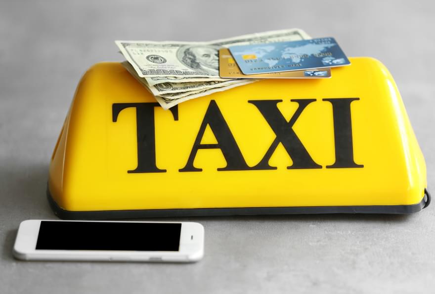 Taxi fare meter and cash on display, emphasizing the importance of knowing taxi rates in Grand Cayman
