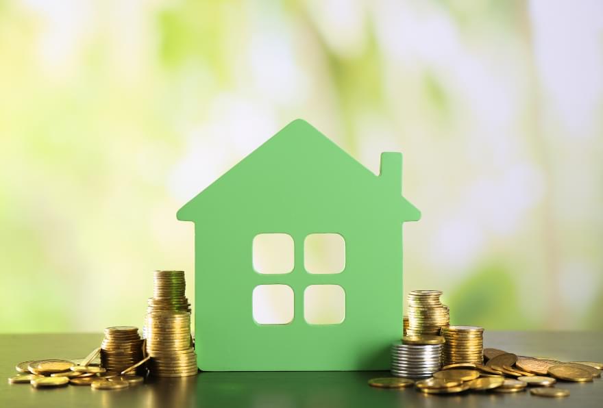 A green house with coins symbolizing investment options for residency in the Cayman Islands
