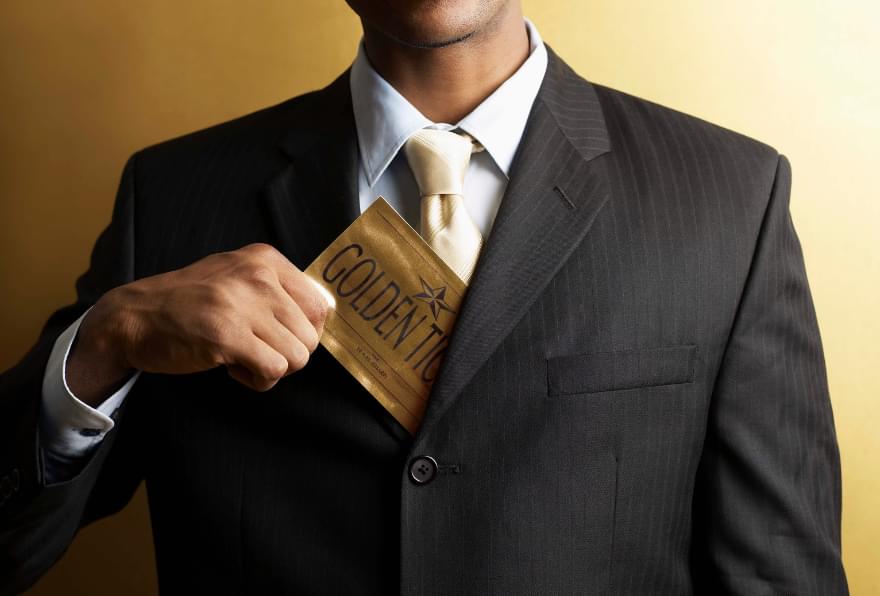 A professional holding a gold visa card showcasing elite residency options in the Cayman Islands