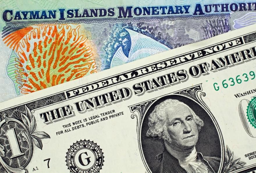 Cayman Islands dollar alongside a U.S. dollar illustrating the fixed exchange rate of Cayman currency to US