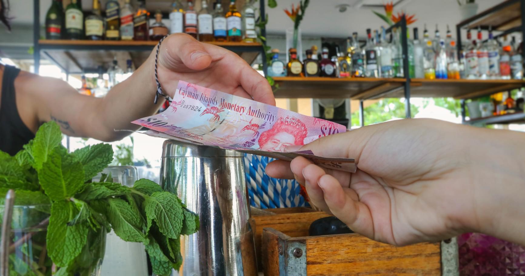 A transaction using money in Grand Cayman at a local café highlighting cash usage for small purchases
