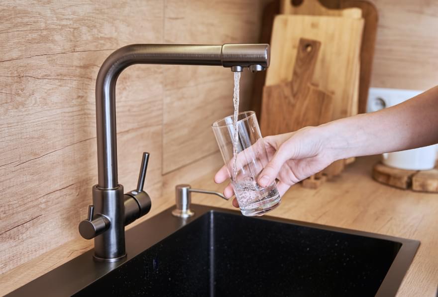 A faucet with running water questioning: is it safe to drink the water in Grand Cayman during your trip