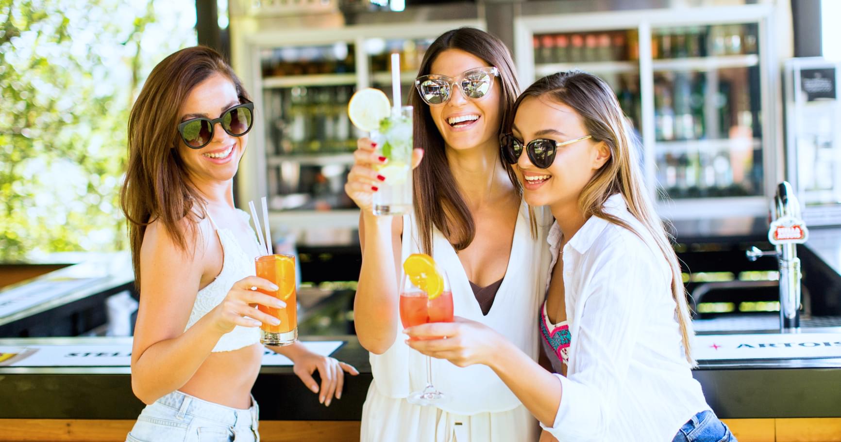 Friends enjoying drinks at a beachfront café in an area where crime on Grand Cayman is minimal