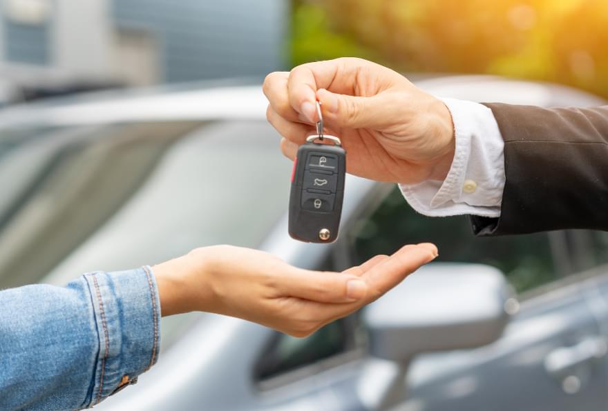 Man handing over keys to woman for longer term rental