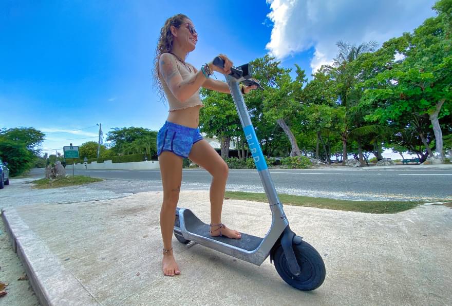 Tourist riding an electric scooter along the coast in Grand Cayman