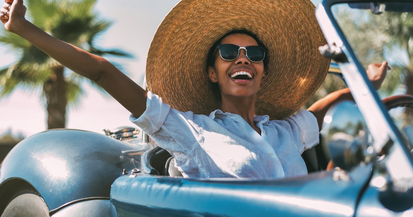 Lady enjoying a scenic drive in a convertible, emphasizing luxury with Cayman car rentals