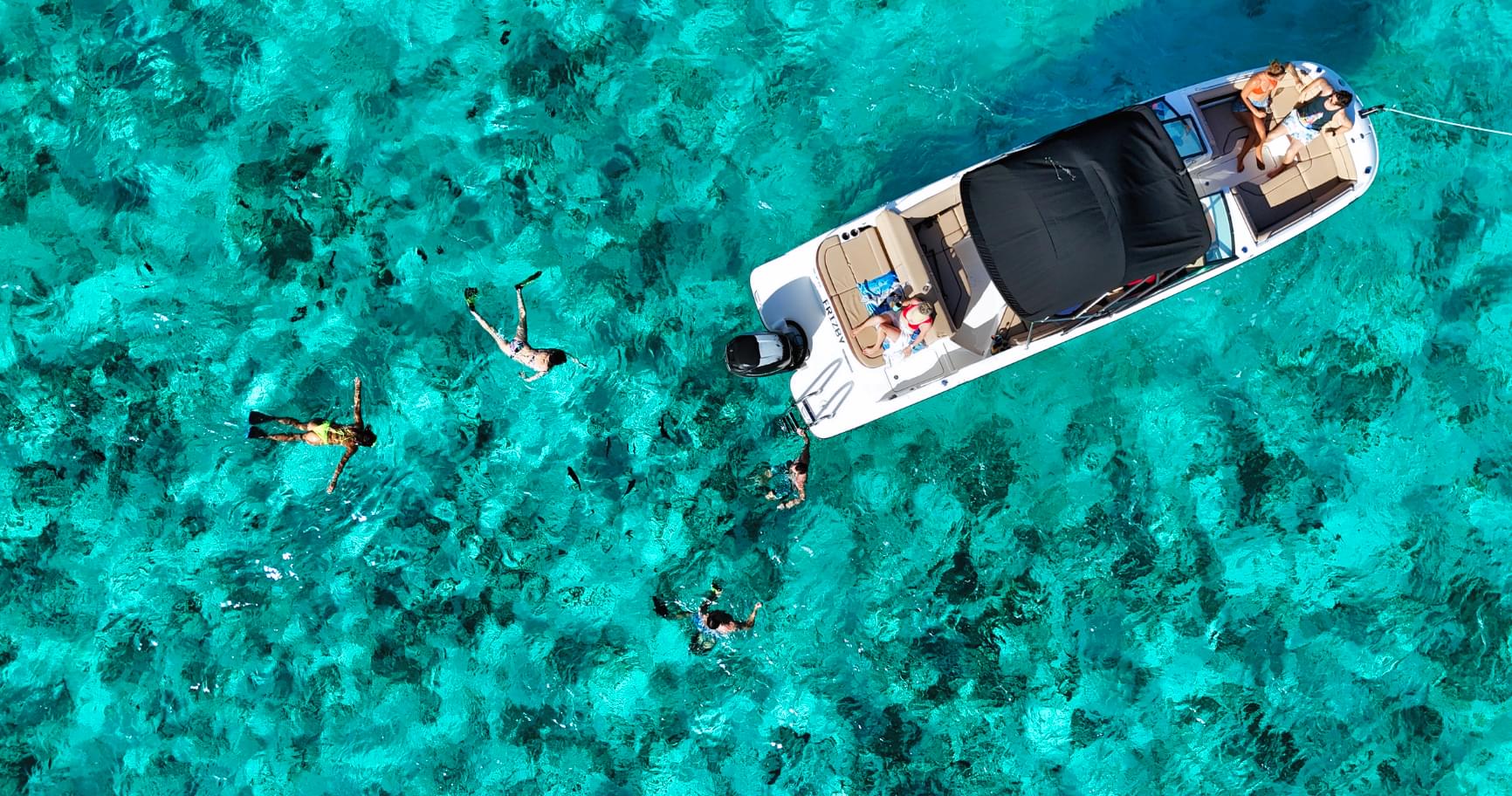 Aerial view of a private boat above turquoise waters in Grand Cayman.