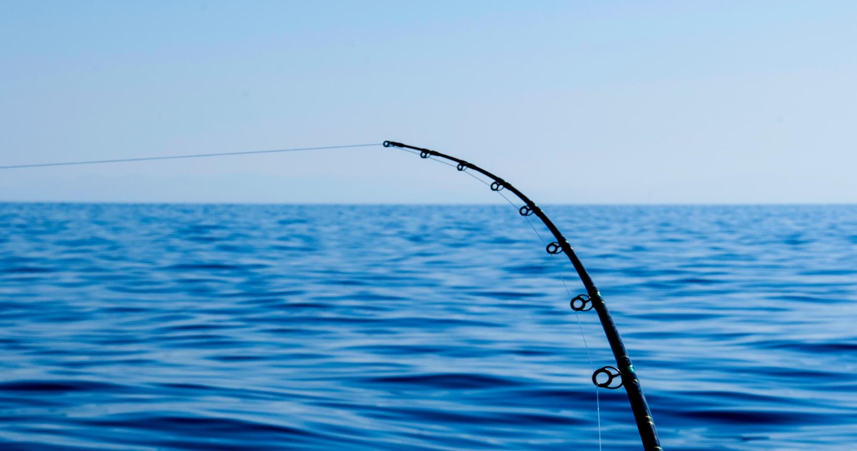 Fishing rod on a boat, highlighting what is there to do in Grand Cayman on deep-sea fishing adventures.