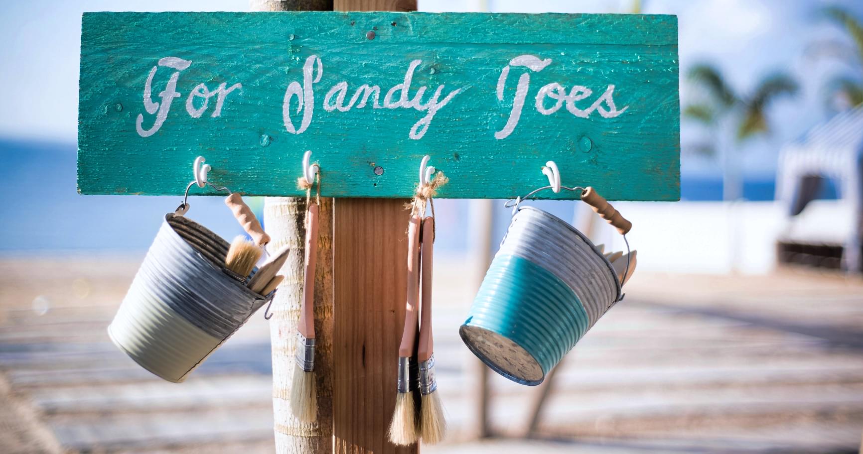 A sign saying "For Sandy Toes" at a peaceful beachfront retreat in Grand Cayman