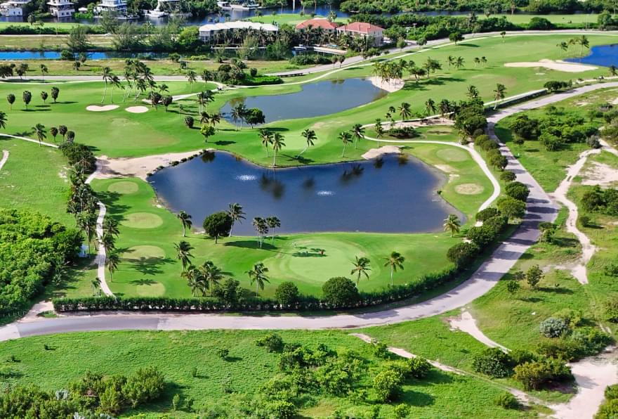 Aerial view of an oceanfront golf course in Grand Cayman, a scenic highlight of Cayman Islands things to do.