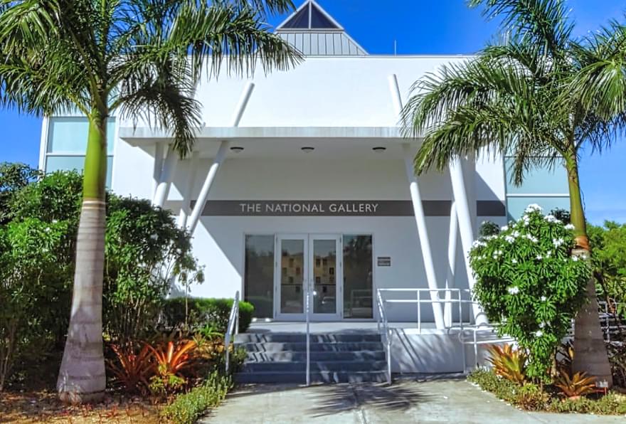 The Cayman Islands National Gallery entrance is surrounded by palm trees, a cultural hotspot.