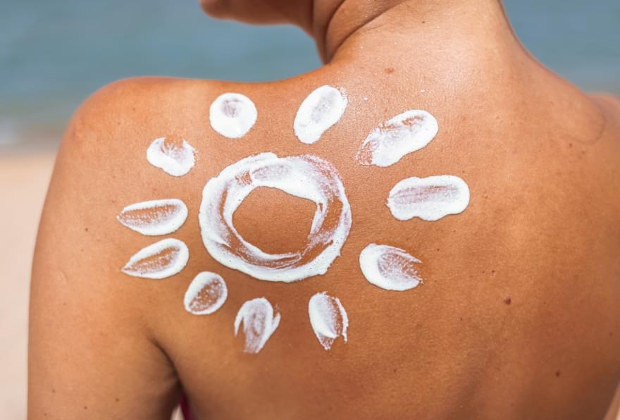 Reef-safe sunscreen design applied to a woman’s back, perfect for Grand Cayman’s sunny beaches