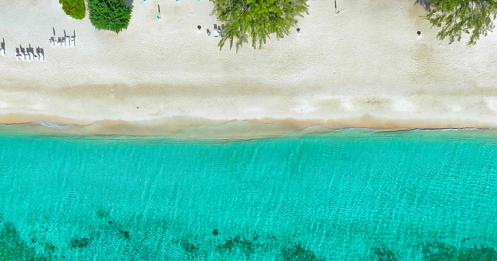 Crystal-clear waters meet white sandy shores on a tranquil beach in Grand Cayman