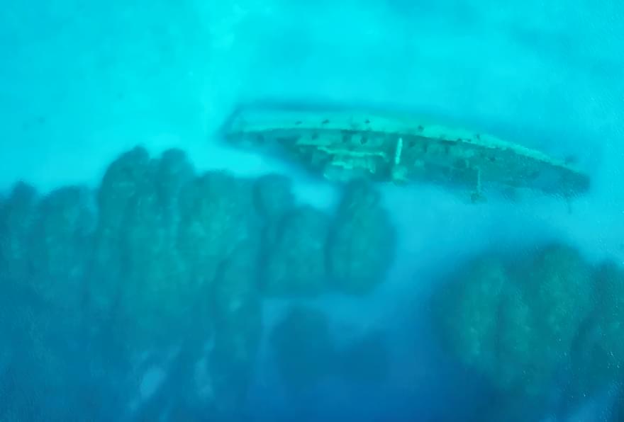Aerial view of the USS Kittiwake shipwreck, an iconic snorkeling site off Seven Mile Beach, perfect for Grand Cayman barrier reef snorkeling