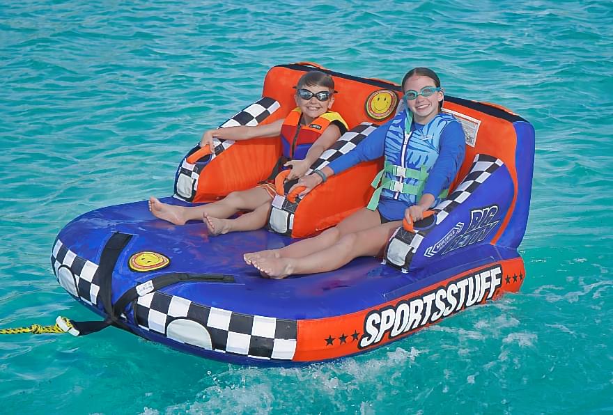Children enjoying a thrilling watersports ride in Grand Cayman's turquoise waters during best excursions in Grand Cayman