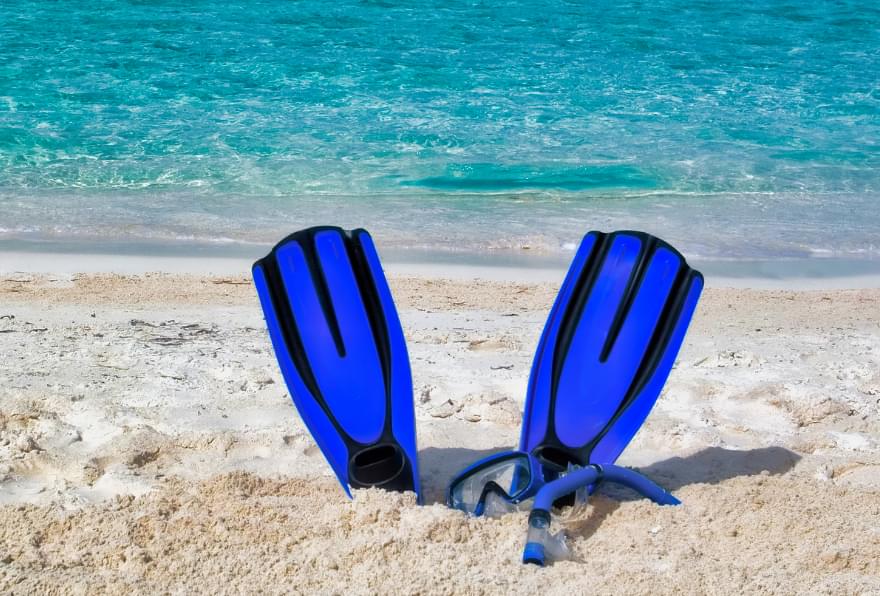Snorkeling gear on a sandy shore in Grand Cayman, perfect for underwater excursions