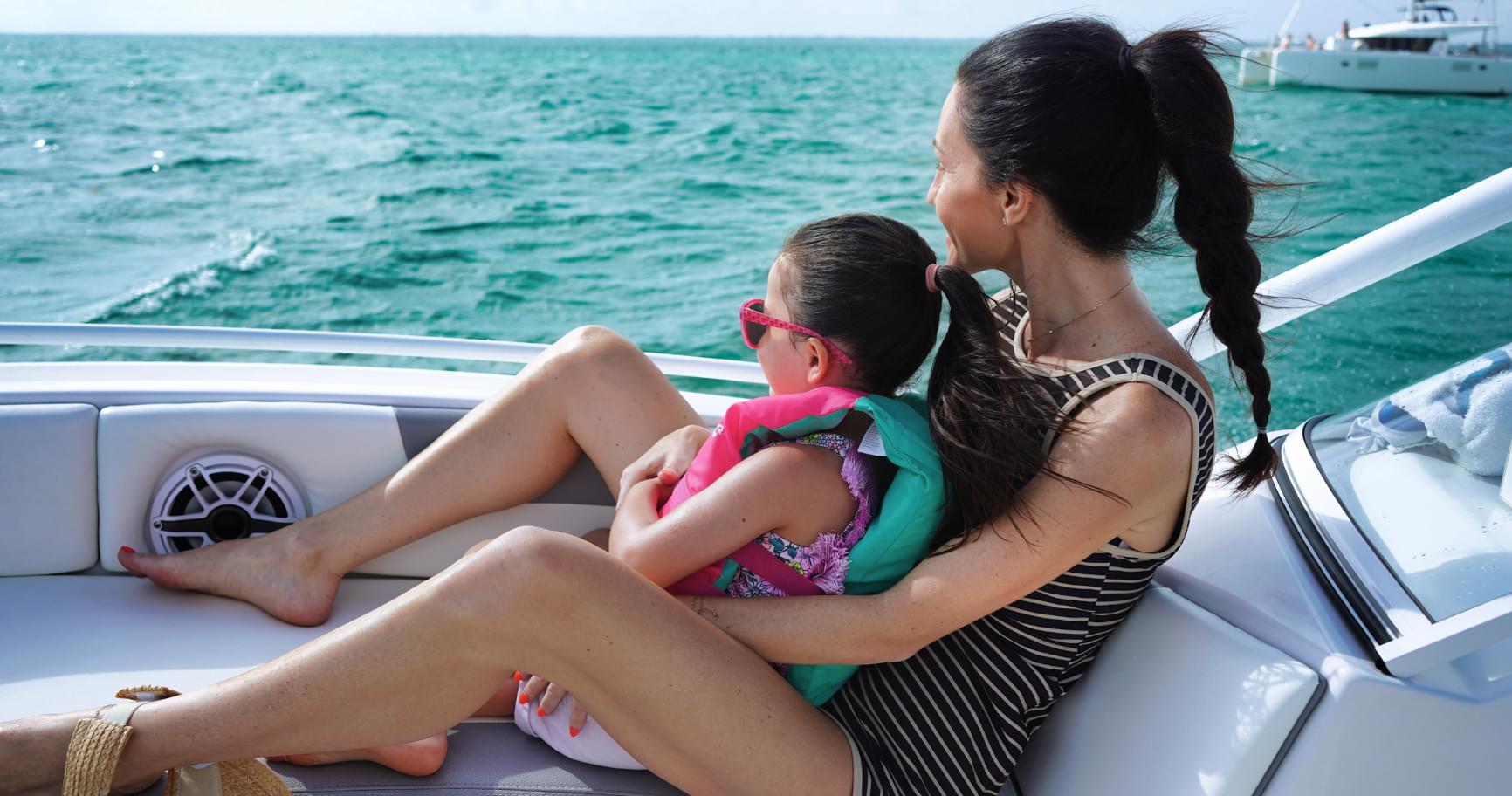 Relaxing on a private boat with a child in Grand Cayman, part of Grand Cayman tours for cruise passengers