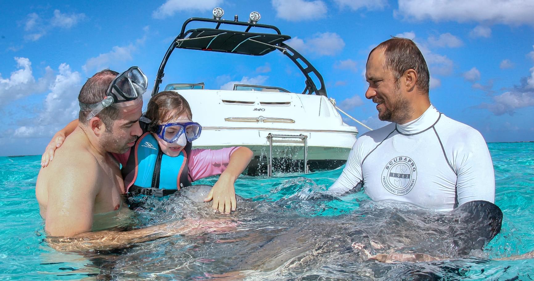 Family interacting with stingrays at Stingray City, enjoying a private moment on the water