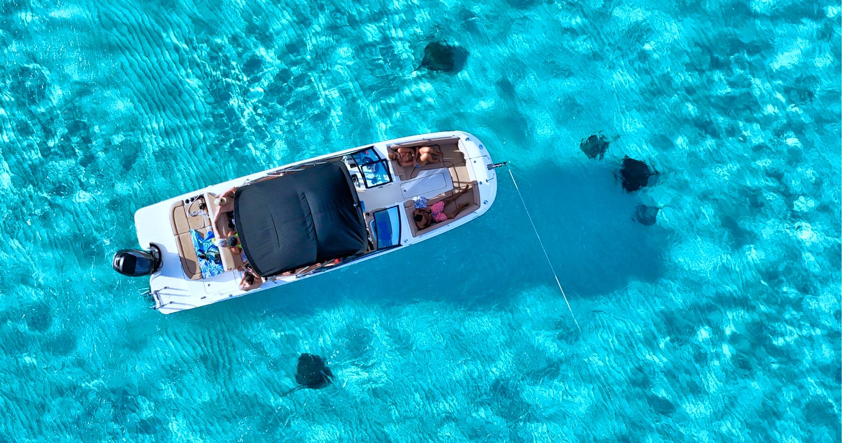 Aerial view of a boat in crystal-clear waters, epitomizing grand Cayman private boat tours