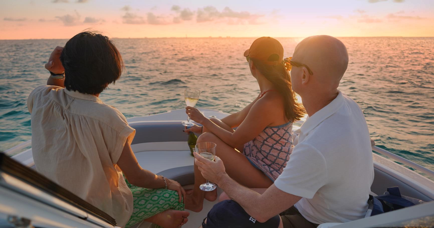 Group toasting on a private boat at sunset, creating memories with a Grand Cayman private charter