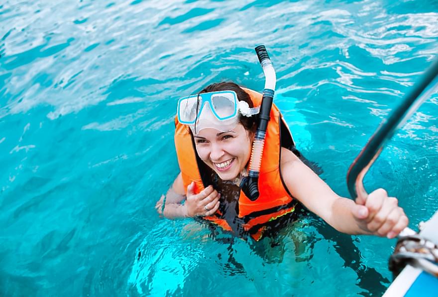 Snorkeler exploring coral reefs, equipped with proper safety gear