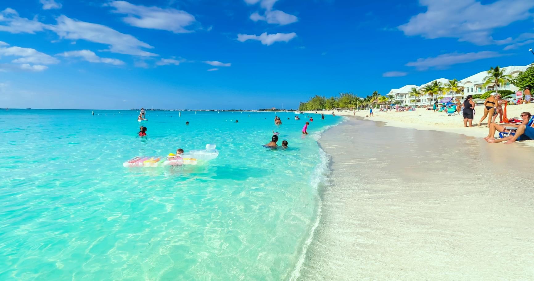 Visitors snorkel in the turquoise waters of Seven Mile Beach, enjoying top attractions in Grand Cayman