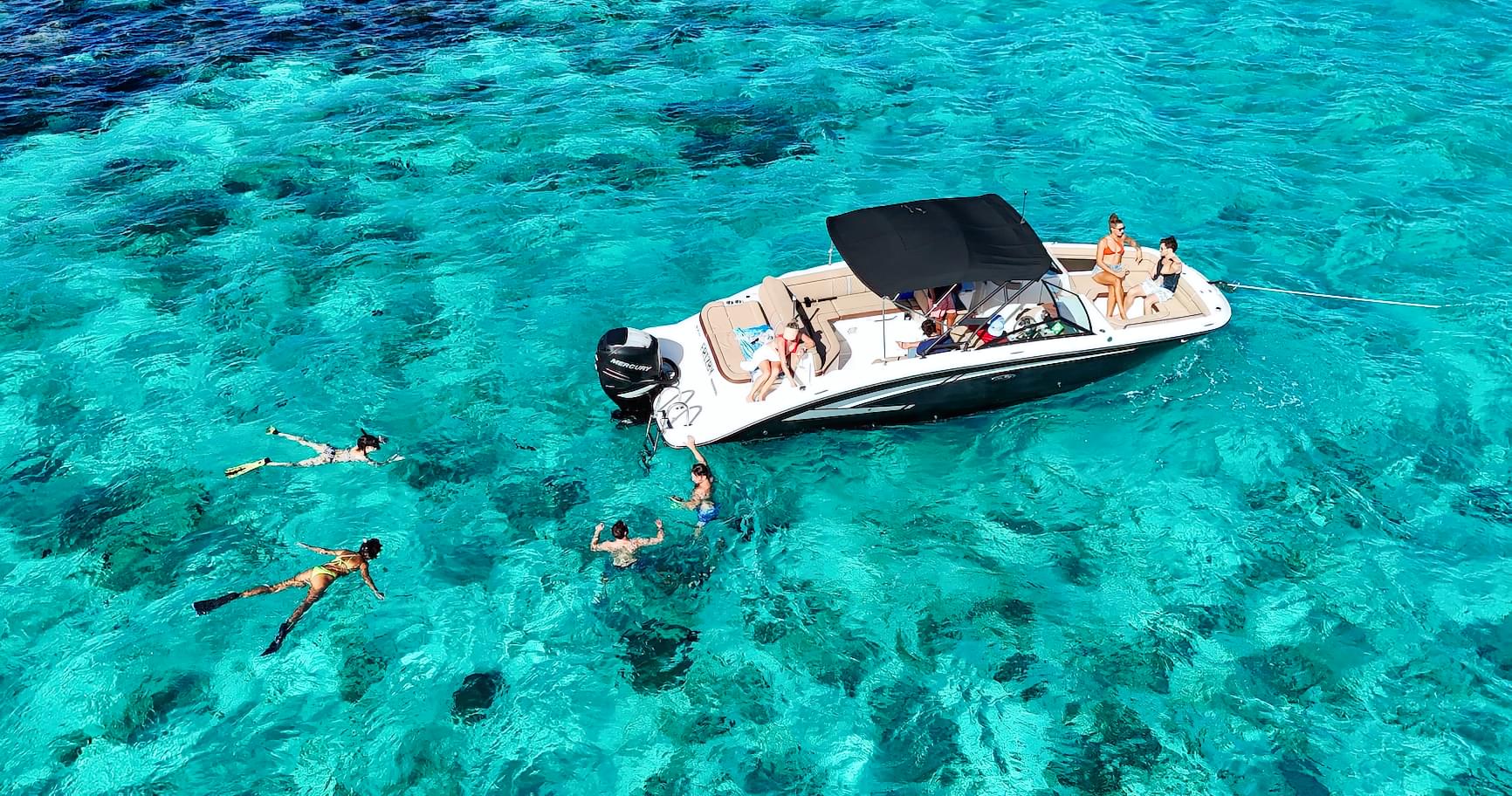 Aerial view of a boat floating in turquoise waters, showcasing Cayman Islands boat rentals