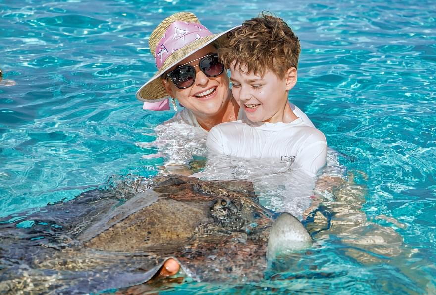 Mother and child interacting with a stingray, creating a magical experience during a tour