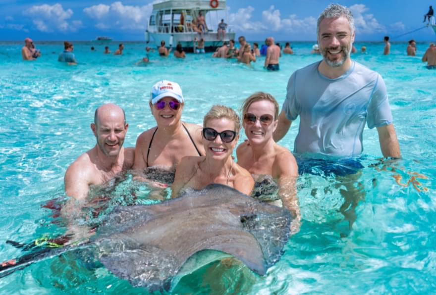 Family enjoying the experience of stingray city tours Cayman, creating memories with marine life