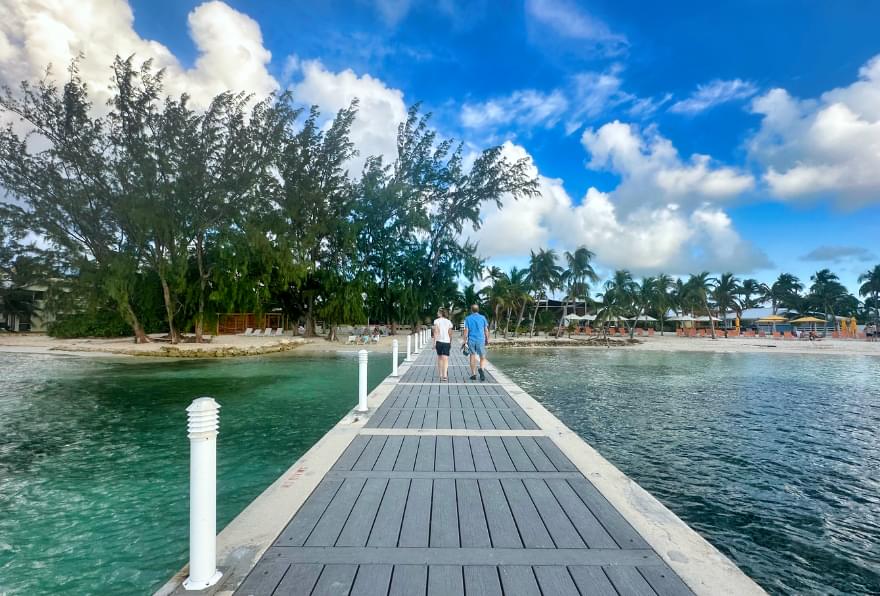 Wooden pier at Rum Point, leading to clear turquoise waters and boats
