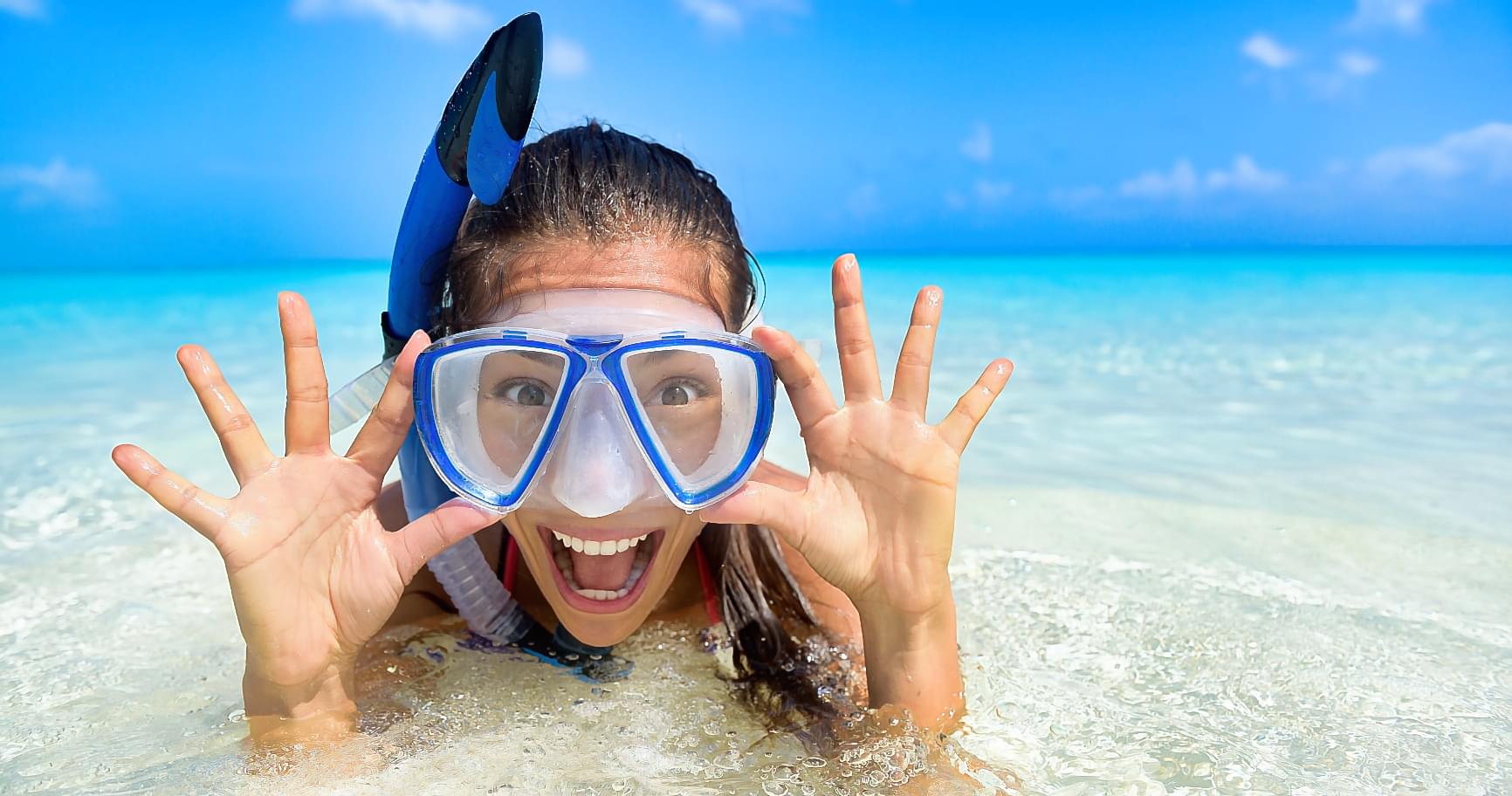 Smiling snorkeler on surface illustrating how to snorkel safely with proper gear